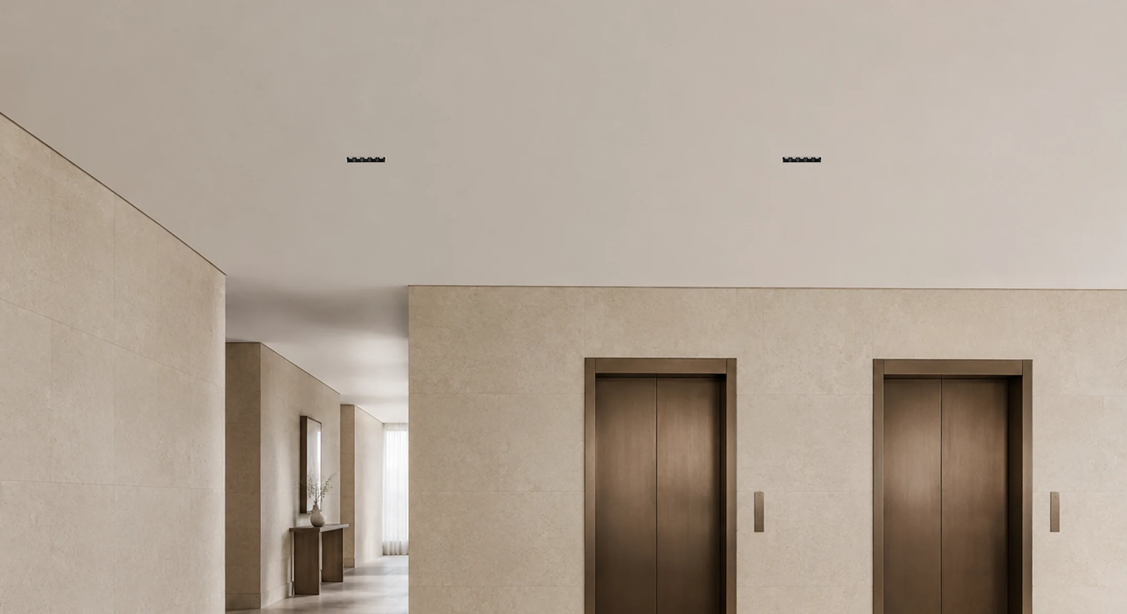 Blade linear downlights integrated into an architectural lift lobby ceiling