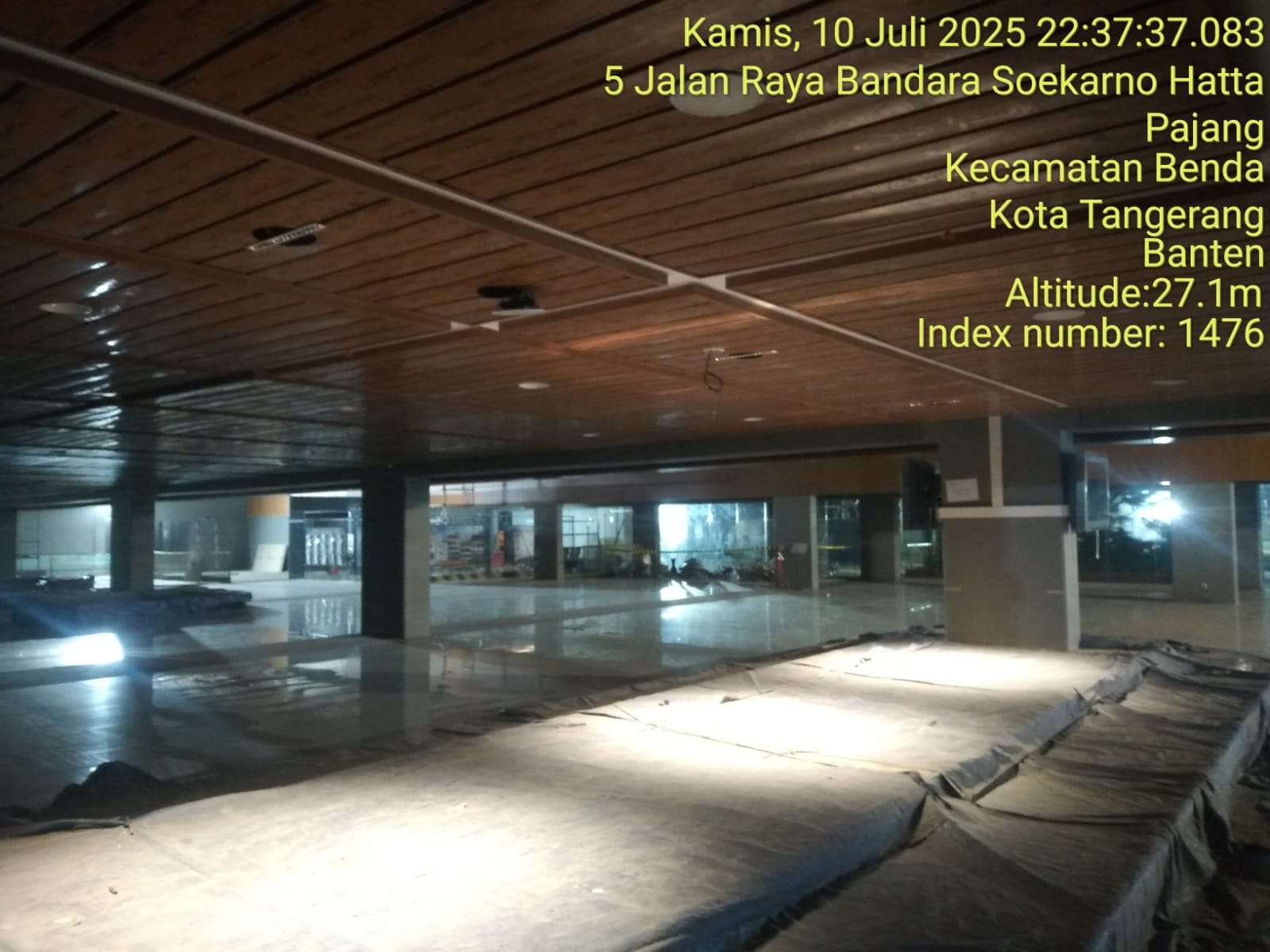 Interior site progress photograph showing ceiling works and unfinished floor areas